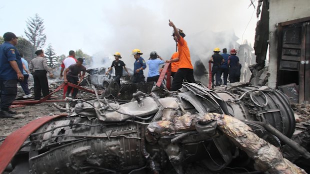 Firefighters and military personnel work at the site.