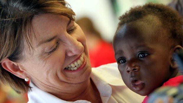 Anna Bligh cuddles David Mitima on January 13, 2011, during a visit to one of the evacuation centres at Queensland Sports and Athletic Stadium in Nathan.