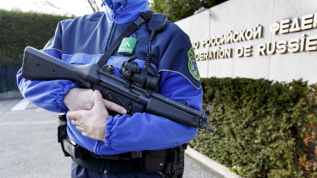 A Swiss police officer controls the area in front of the Russian mission in Geneva on Thursday.