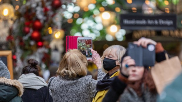 Crowds of people in Covent Garden, London for Christmas, but not everyone wears a mask.