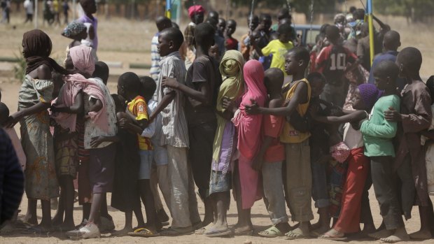 Children, who have been displaced after attacks by Boko Haram, line up in a refugee camp in Yola, Nigeria. 