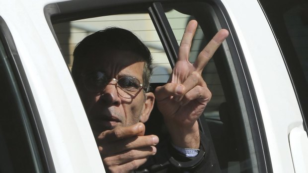 Seif Eldin Mustafa flashes the victory or peace sign as he leaves a court in Cyprus on Wednesday.  
