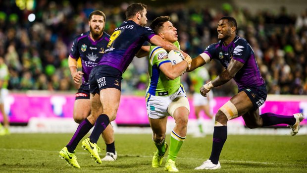 Joseph Tapine is tackled by Cameron Smith (left) and Suliasi Vunivalu.