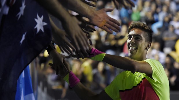 Thanasi Kokkinakis celebrates with the crowd after winning his first-round match.