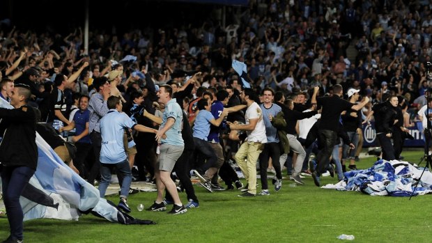 Pitch invasion: Sydney FC fans flood the Allianz Stadium pitch after the dramatic Sydney derby last month.