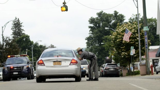 A New York state trooper talks to a motorist on Main Street in Friendship, New York, where there was a possible sighting of the escaped convicts.