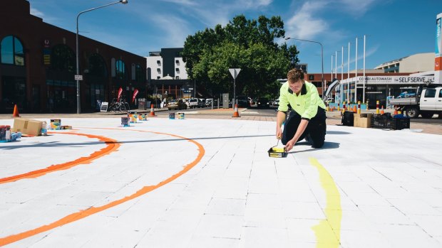 A painter prepares the roundabout for volunteers to paint this week.