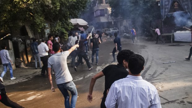 Supporters of the Muslim Brotherhood aim their fireworks toward Egyptian security forces following their protest against the government on Tuesday.
