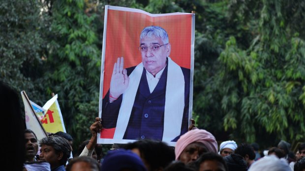 Devotees of Indian self-styled ''godman'' Rampal Maharaj hold a poster of his image during a sit-in protest in Delhi.