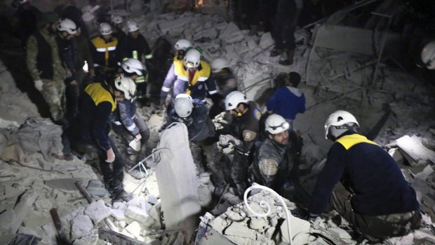 Syrian White Helmets workers inspect the damage after a bombing that targeted the office of Ajnad al-Koukaz, a militant group consisting of foreign fighters mostly from the Caucuses and Russia, in Idlib, Syria, on Sunday.