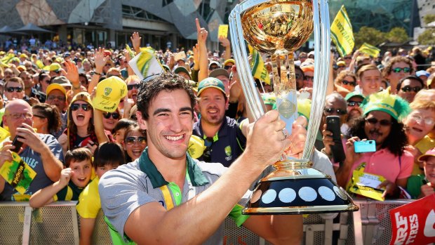 Mitchell Starc poses with the ICC Cricket World Cup trophy in front of fans at Federation Square.