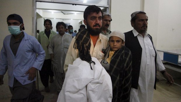 Relatives carry a boy who survived the attack into a hospital in Quetta, Pakistan.