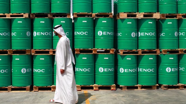 A visitor passes ENOC-branded oil barrels stored at the Emirates National Oil Co. 