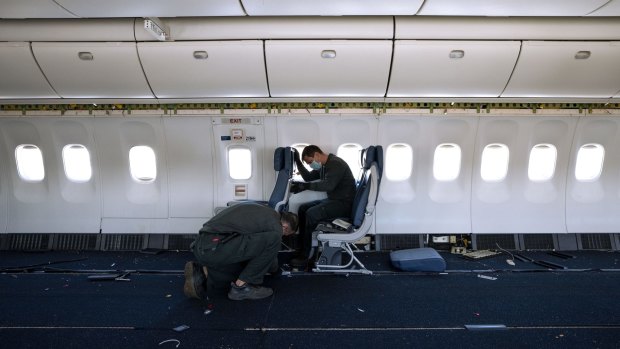 Engineers remove the final passenger seats.