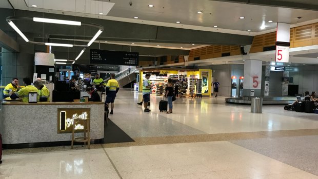 Qantas ground crews in a deserted domestic terminal, as a storm hits Sydney.