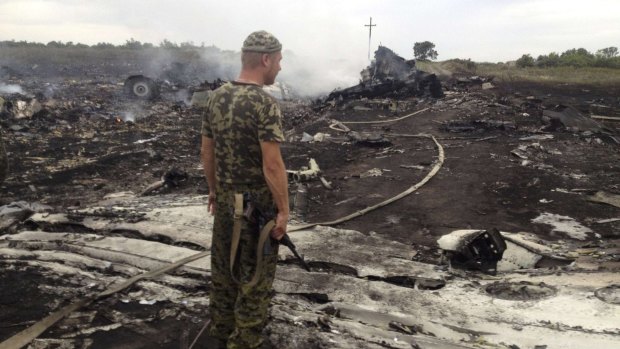 An armed pro-Russian separatist stands at the crash site last year.