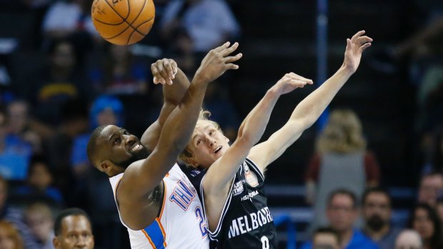 Oklahoma City Thunder guard Raymond Felton (left) and Melbourne United guard Kyle Adnam reach for a rebound.