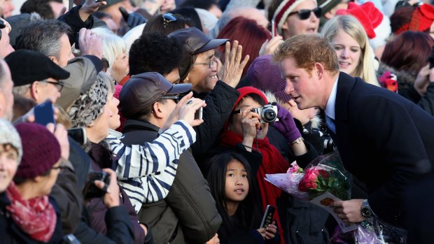 Crowd-pleaser: Prince Harry greets well-wishers outside the chapel.