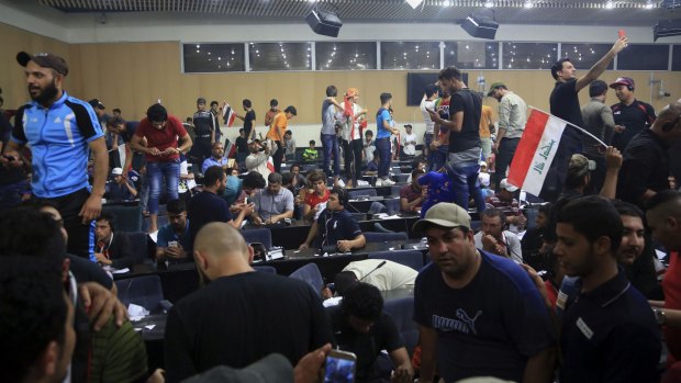 Iraqis take pictures after occupying Iraq's parliament building.