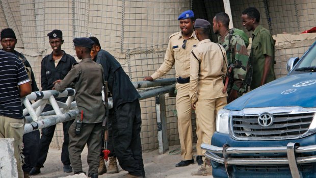 Somali police guard the road leading to the scene of the suicide bomb attack.