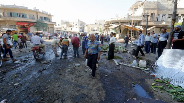 Residents gather at a market damaged by what activists said was an air strike by forces of Syria's President Bashar al-Assad on Tuesday.