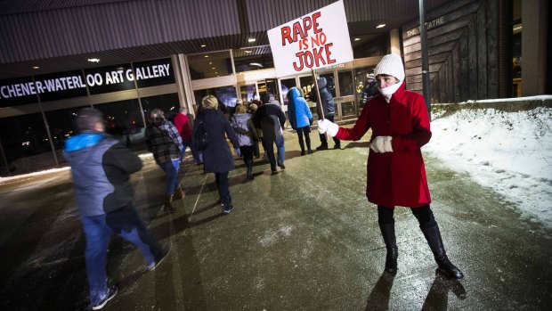 A woman protests as people walk into the Kitchener venue where Bill Cosby was performing.