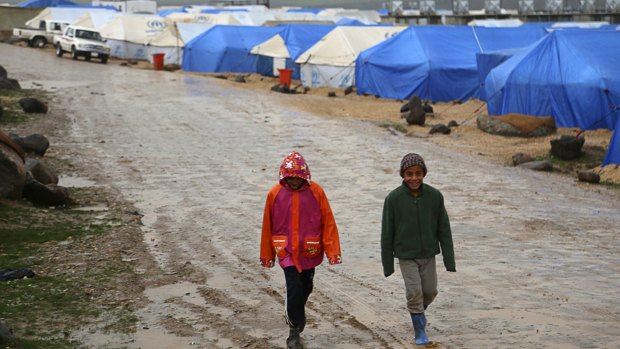 Yazidi children walk outside tents at Nowruz refugee camp in Qamishli, northeastern Syria.