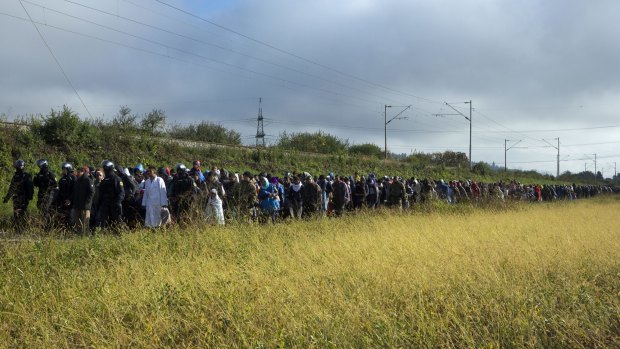 Refugees walk towards a reception facility after crossing into Slovenia from Croatia.