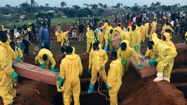 Volunteers handle a coffin during a mass funeral for victims of heavy flooding and mudslides in Regent at a cemetery in Freetown, Sierra Leone. Churches across Sierra Leone held special services Sunday in memory of the hundreds killed.