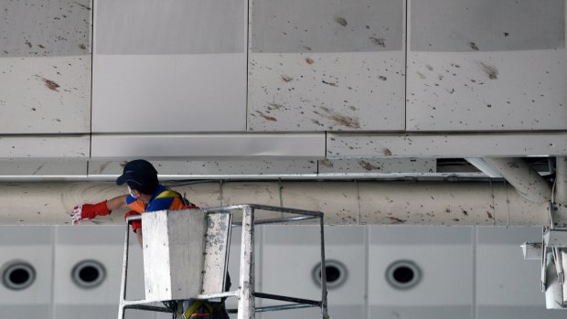 A worker wipes traces of blood from the wall of Ataturk Airport.