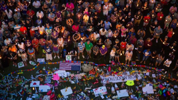 Mourners attend a candlelight vigil in Orlando the day after an attack on a gay nightclub left at least 50 people dead.