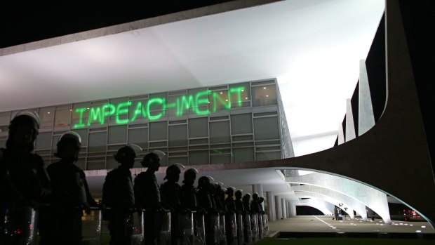 Soldiers stand guard outside Brasilia's Planalto presidential palace on Monday when protesters projected the word "impeachment" on the building.
