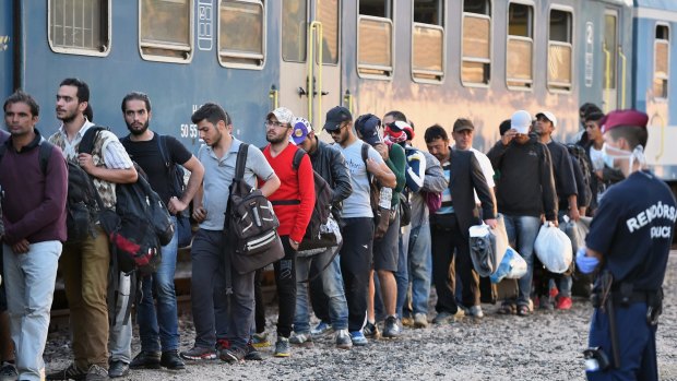 Migrants board a train at Magyarboly station in Hungary, heading for Austria on September 22. Thousands of migrants passed through Hungary, Croatia and Slovenia.
