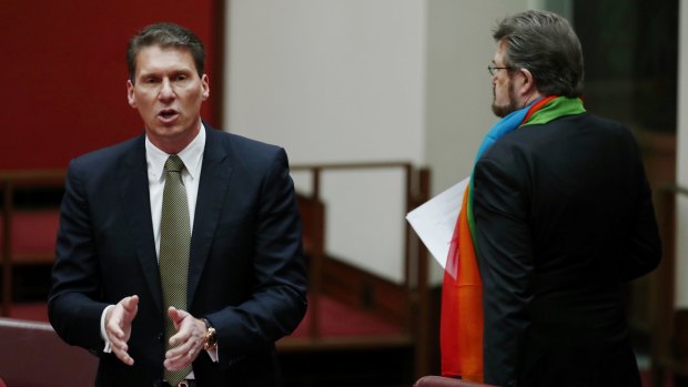 Senator Cory Bernardi walks past Senator Derryn Hinch in the Senate. 
