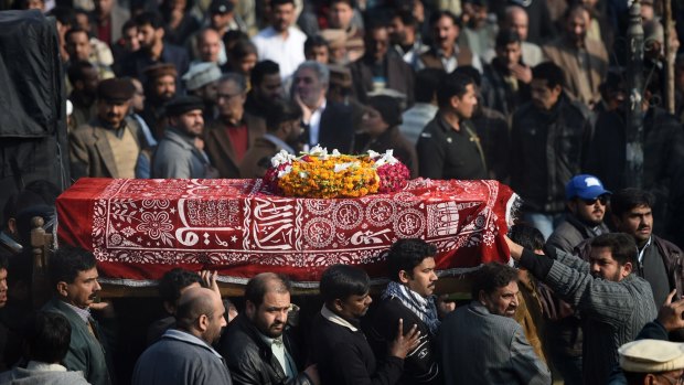 Pakistani Shiite Muslims carry the coffin of a suicide blast victim as they arrive for the funeral ceremony in Rawalpindi on January 10.