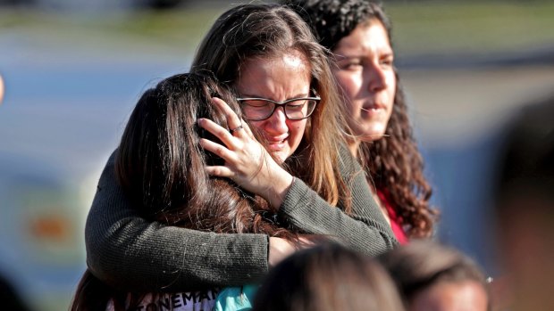 Students released from a lockdown embrace following the shooting.