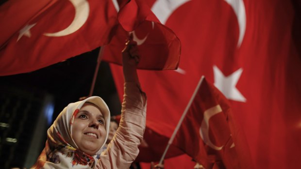 A woman waves Turkish flags during a rally against the attempted coup in Istanbul on Monday.