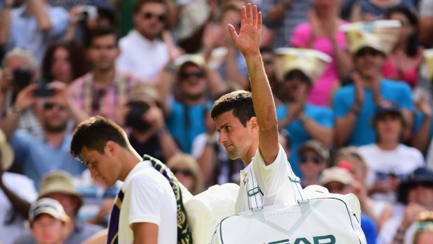 Novak Djokovic waves to the crowd as he leaves the court after beating Bernard Tomic. 