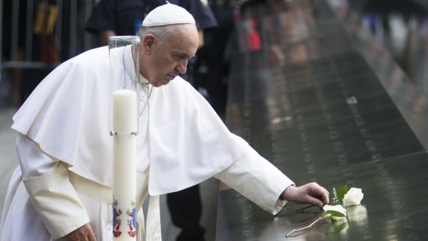 Pope Francis places a white rose at the South Pool of the 9/11 Memorial after praying for the victims and families touched by the terrorist attack in downtown Manhattan in New York. 