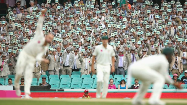 Nathan Lyon bowls as the Richie Benaud impersonators hold up their microphones during day two of the third Test against the West Indies at the SCG last year.