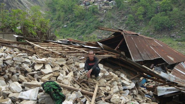 A villager sits on his collapsed home in the destroyed village of Jalingi, near the epicentre of Saturday's massive earthquake, in the Gorkha District of Nepal.