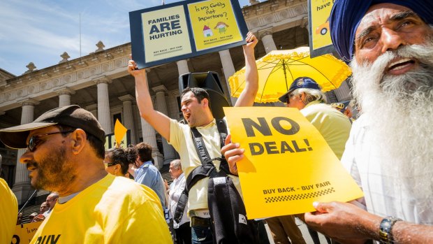 Taxi drivers Aytac Arman (c) and Nirmal Singh Sekhon (r) protest on the steps of Parliament house on December 3, 2016 in Melbourne, Australia. 