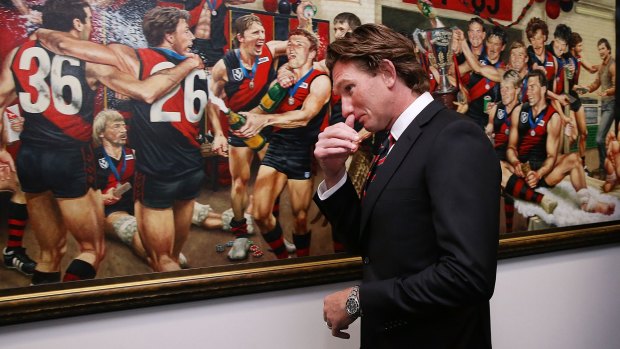 Former Bombers head coach James Hird walks past a painting dedicated to the 1984 and 1985 premiership teams before his press conference at the club's headquarters on Tuesday.