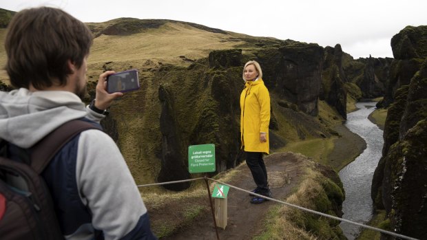 Russian tourist Nadia Kazachenok poses for a photograph at the canyon. Tourists jumped the gate as soon as the ranger went off duty.