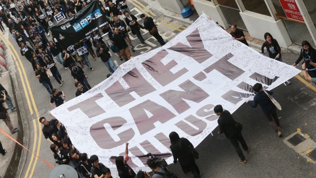 Members of the Hong Kong Journalists Association, staffs of <i>Ming Pao</i> newspaper and supporters hold a banner in a march in Hong Kong in 2014.