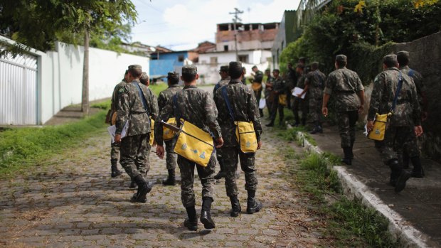 Brazilian soldiers canvass a neighbourhood to tell residents to prevent mosquito bites.