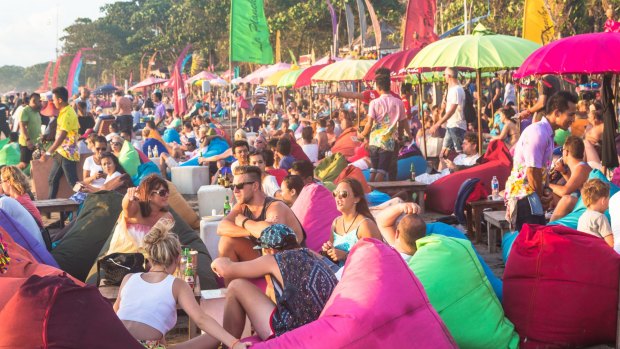 Tourists enjoy a drink in a beach bar along Seminyak beach, just north of Kuta, in Bali.