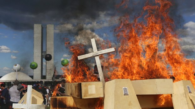 Striking police officers set fire to coffins during a protest against pension reforms outside Congress in Brasilia, on Tuesday.