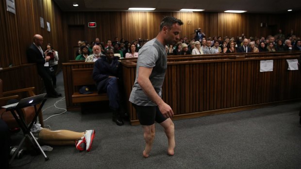 Oscar Pistorius walks across the courtroom without his prosthetic legs during the third day of his hearing for a resentence at Pretoria High Court.