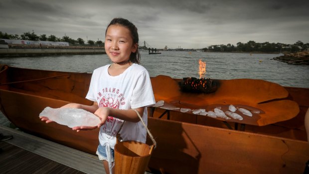 Riana Shimamune holds a frozen fish about to be cast into the firey canoe.